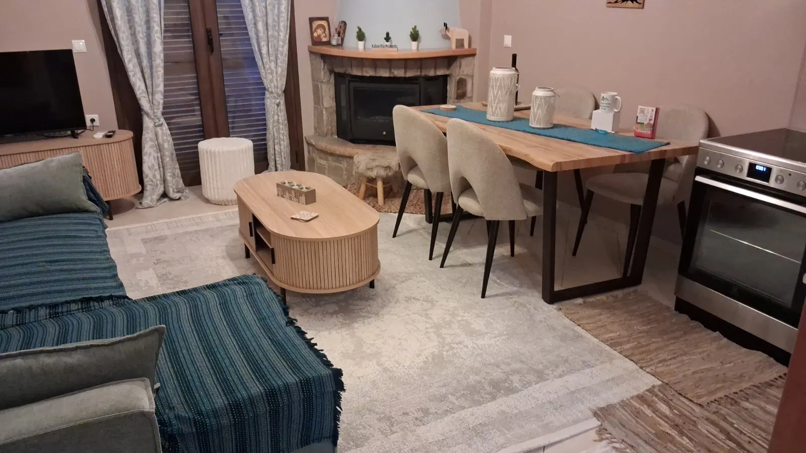 Το καθιστικό με τον καναπέ και το τραπέζι φαγητού δίπλα στο τζάκι